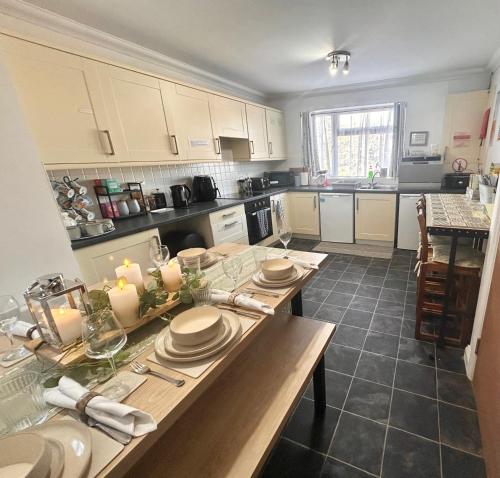 a kitchen with a table with plates and candles on it at The Nest at Wynncroft in Torquay