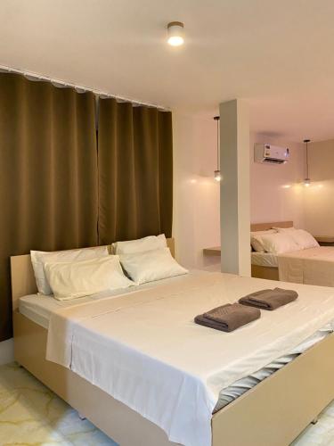 a bedroom with a large bed with white sheets at Isla Haus Boracay in Boracay