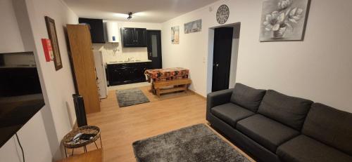 a living room with a couch and a kitchen at Apartment by the Beach Praia da Areia Branca in Lourinhã