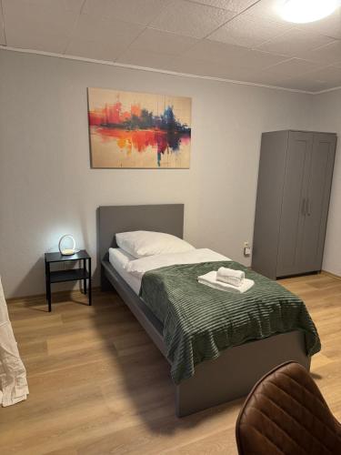 a bedroom with a bed with a green blanket at ZV38-Alter Weg-OG in Salzgitter