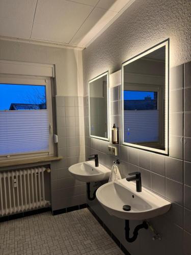 a bathroom with two sinks and two mirrors at ZV38-Alter Weg-OG in Salzgitter