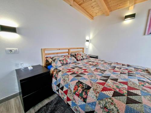 a bedroom with a bed with a quilt on it at Apartments Casa Sossa in Vilanija