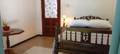 a bedroom with a bed with two pillows on it at Wooden hostel in Weligama