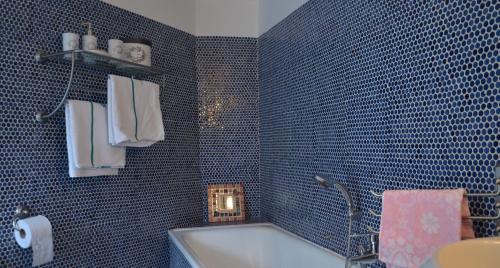 スパにあるLe Petit Maurの青いタイル張りのバスルーム(バスタブ、シンク付)