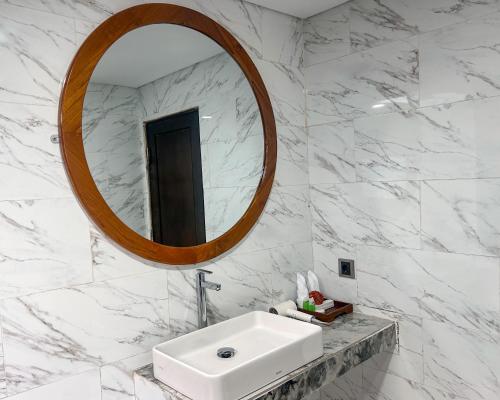a white bathroom with a sink and a mirror at The Hills Penida in Nusa Penida