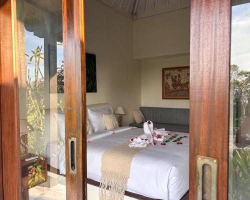 a bedroom with a bed with a stuffed animal on it at The Hills Penida in Nusa Penida