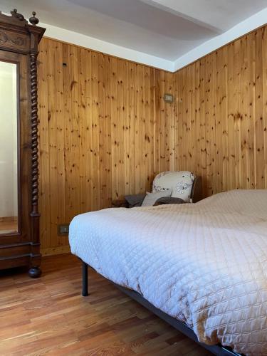 ein Schlafzimmer mit Bett und Holzvertäfelung in der Unterkunft CadlaNona in Boves