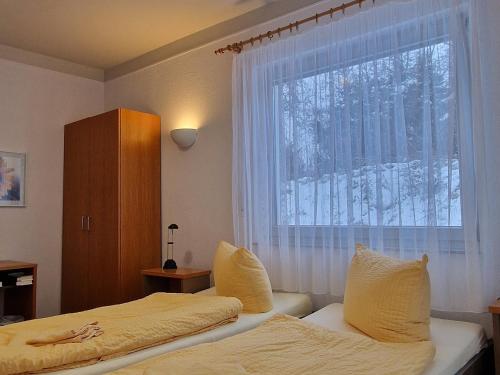 a bedroom with two beds and a window at Gästehaus Dominikus in Leipzig