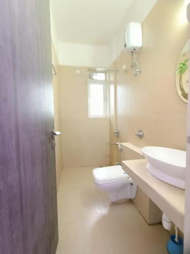 a white bathroom with a sink and a toilet at 3 bedroom Shreeji's Viila with Private pool in Lonavala