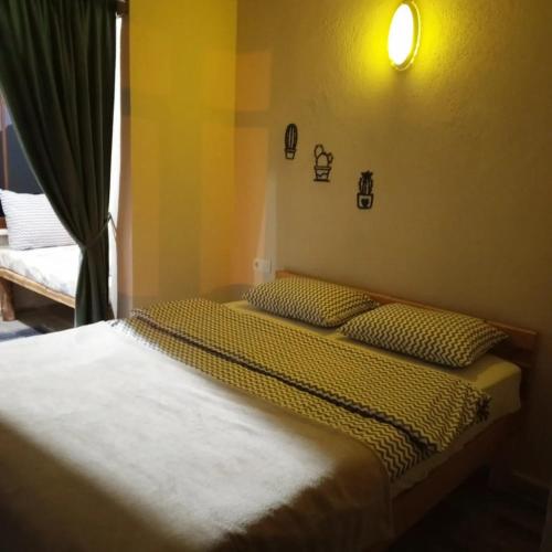 a bedroom with two beds and a light on the wall at Balcı Konukevi in Artvin