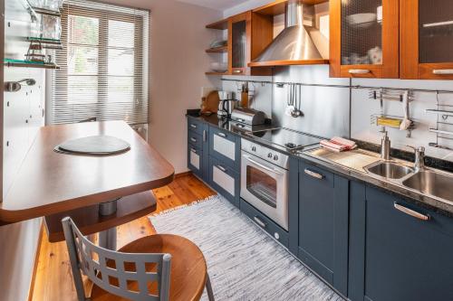 a kitchen with blue cabinets and a wooden table at Villa Santer in Dobbiaco