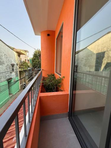 a balcony with orange walls and a window at Lien Home in Thôn An Hòa