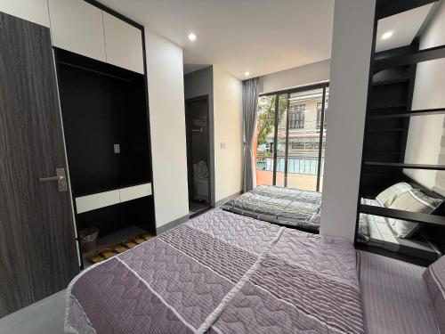 a bedroom with two beds and a flat screen tv at Lien Home in Thôn An Hòa