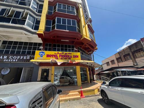 a building with a red and yellow sign on it at Hotel O Peneka Inn in Kota Bharu