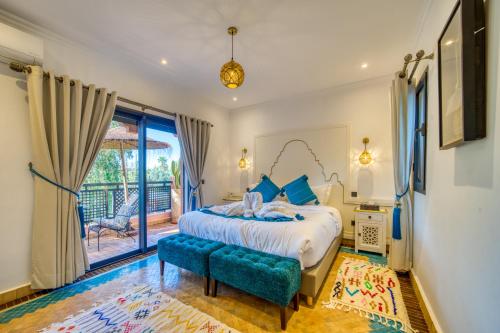 a bedroom with a bed and a large window at Villa JUZYAN une parenthèse de bien-être et de convivialité in Marrakesh
