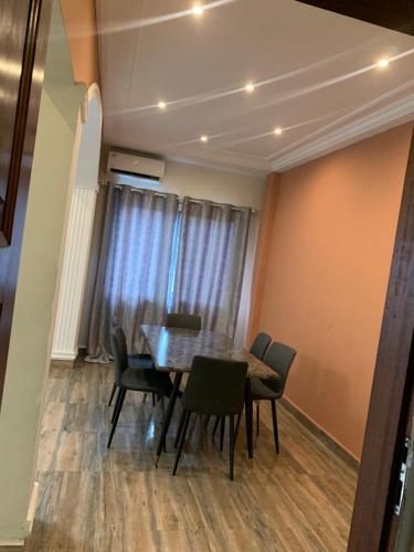 una sala da pranzo con tavolo e sedie di MRGAppart a Brazzaville