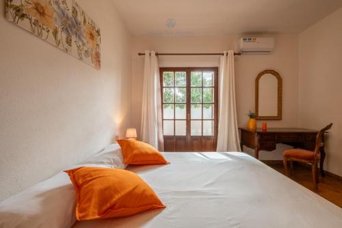 a bedroom with a bed with two orange pillows on it at Domo de Iannas-House Live Express in Quartu Sant'Elena