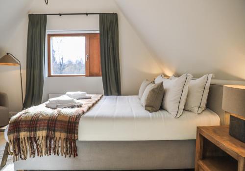 a bedroom with a large bed with a window at Le Gîte du Haras in Falaën