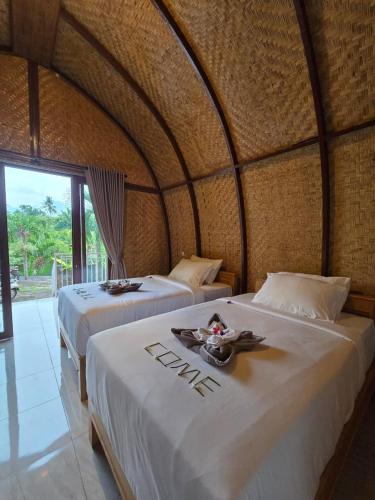 a room with two beds in a tiki room at Eco Moringa Garden in Banyuwedang