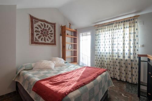 a bedroom with a bed and a window at Casa modernista in La Zubia
