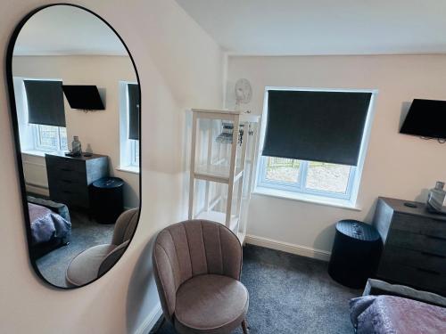 a bedroom with a mirror and a chair and a bed at Barber House, Hoyland with two allocated parking spaces in Hoyland Nether