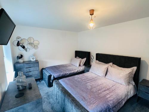 a bedroom with two beds and a tv in it at Barber House, Hoyland with two allocated parking spaces in Hoyland Nether