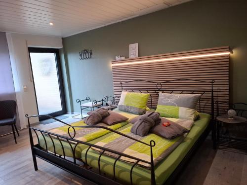 a large bed in a bedroom with a headboard at Pension-Jakobs in Nachtsheim