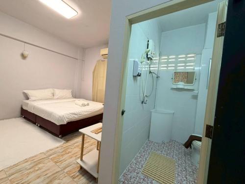 a small room with a bed and a shower at Saan Stay in Ban Krabi Yai