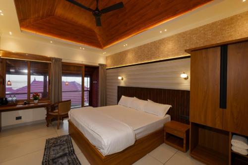 a bedroom with a bed and a desk and a window at Adonna Beach Resort in Alleppey