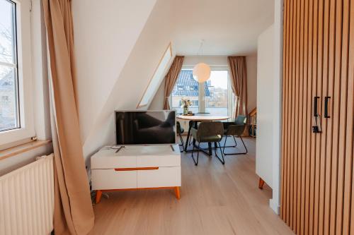 a living room with a tv and a table at Ferienwohnung Wirbelwind in Scharbeutz