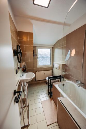 a bathroom with a tub and a sink and a bath tub at Ferienwohnung Wirbelwind in Scharbeutz