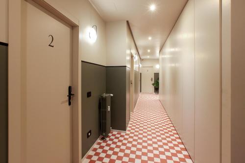 a hallway with a red and white checkered floor at Cà Bèla - Venini in Milan