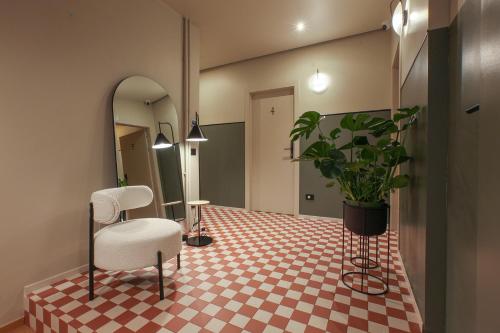 a room with a mirror and a chair and a table at Cà Bèla - Venini in Milan