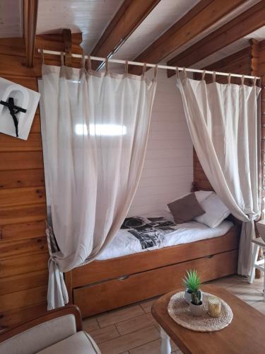 un lit dans une chambre avec un rideau dans l'établissement Chalet, au Teich