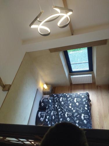 an attic room with a bed and a window at La Tour de Vesly in Belval