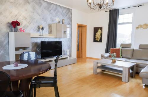 a living room with a table and a couch at Bryza Homes - Villa Linde - Parkplatz - Ahlbeck - Patio in Ahlbeck