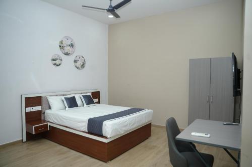 a bedroom with a bed and a table and a desk at Ravi Convention Centre in Rājānagaram