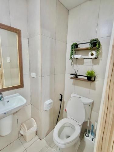 a white bathroom with a toilet and a sink at Yugen Studio in Davao City