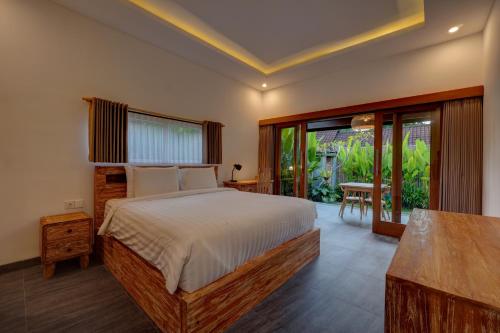 a bedroom with a large bed and a table at Ratih Guest House in Ubud