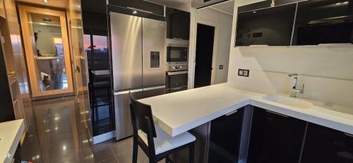 a kitchen with a white counter and a sink at Espectacular ático en 1°linea playa in Rota