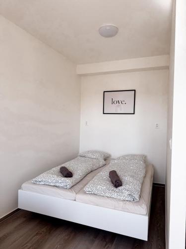a white bed with two pillows in a room at District B Apartments in Brno