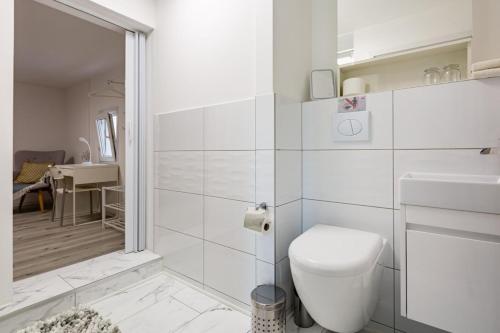 a white bathroom with a toilet and a walk in shower at Immensee Appartments by Mainka Properties in Immensee