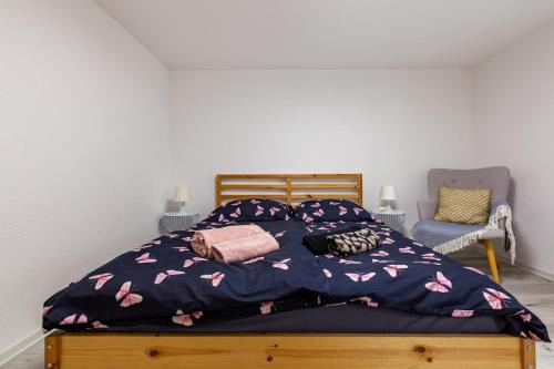 a bedroom with a bed with a blue comforter and a chair at Immensee Appartments by Mainka Properties in Immensee