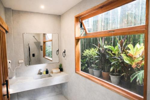a bathroom with a sink and a window with plants at Moringa Private Room in General Luna