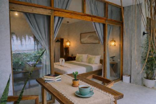 a room with a bed and a table with a coffee cup at Moringa Private Room in General Luna