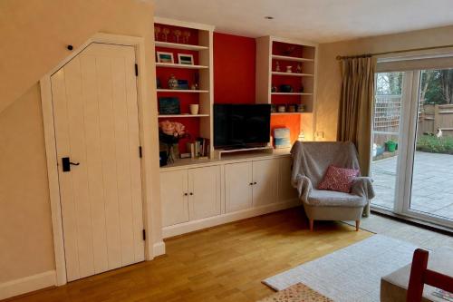a living room with a television and a chair at Yew Tree House in Arundel