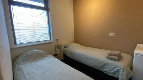 a small room with two beds and a window at Vakantieverblijf in Wijnbergen in Wijnbergen