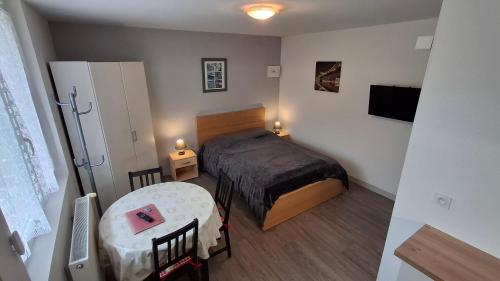 a small bedroom with a bed and a table at Résidence L'IDEALE in La Roche-Posay