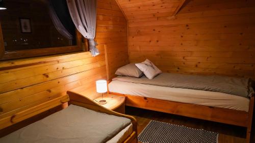 a room with two beds in a log cabin at Zielona Dolinka in Kostrzyca
