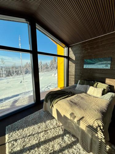a bedroom with a bed and a large window at Mystical Lapland Suite in Rovaniemi